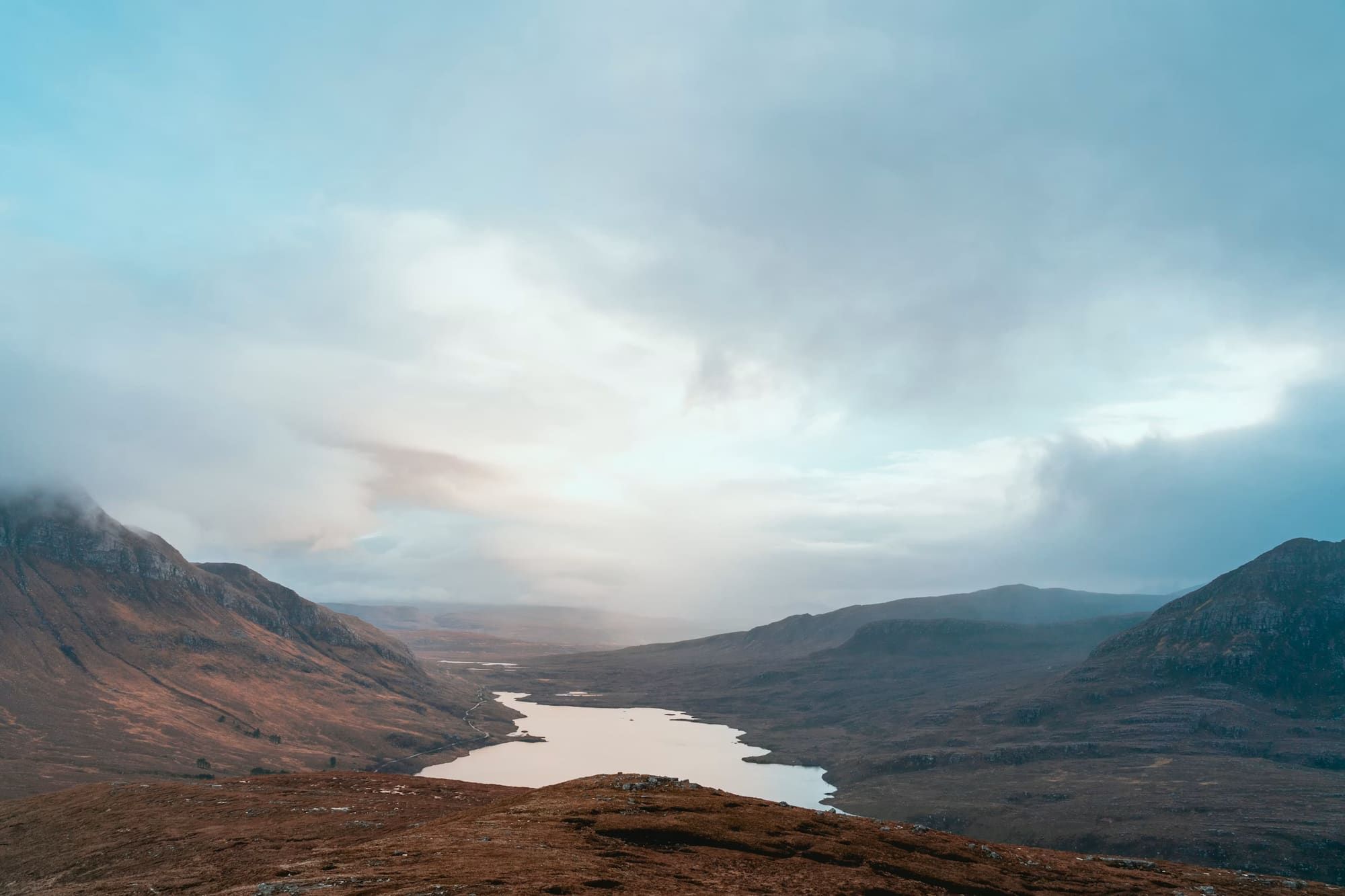 Brown mountains beneath cloud