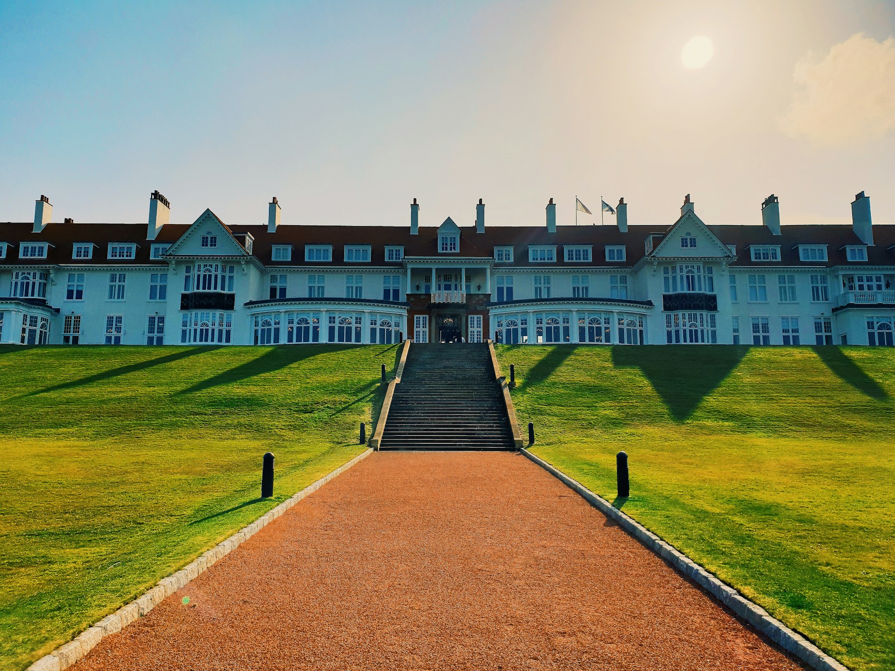 A grand golf hotel and clubhouse at golden hour