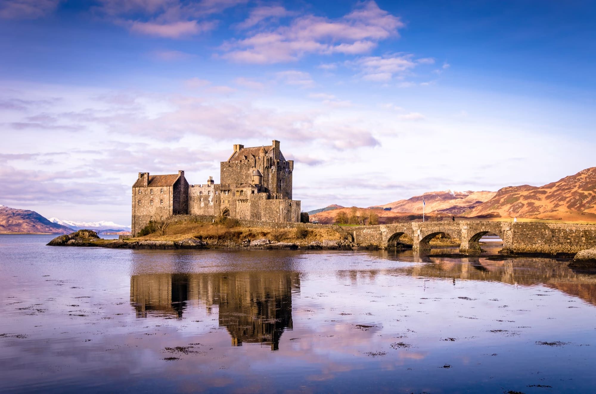 A stone bridge with a castle in the background