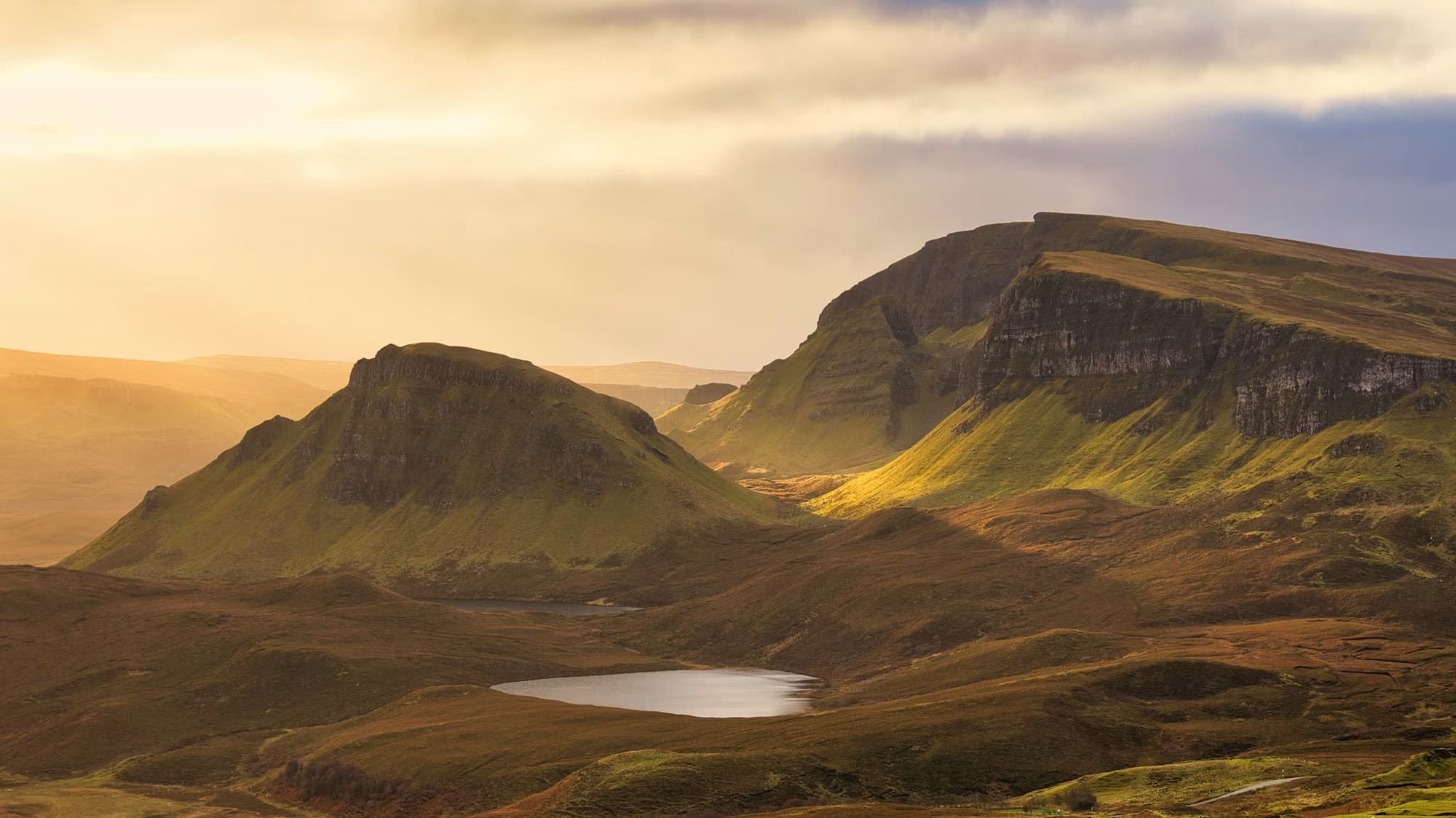 A sweeping Highland loch, framed by misty mountains at dawn